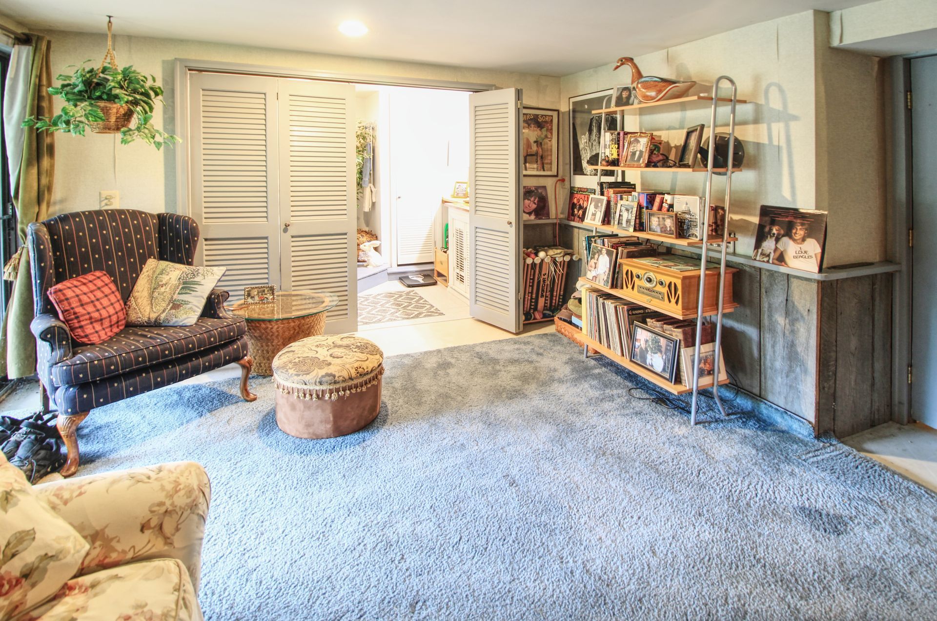 A living room with a couch , chair and ottoman.