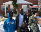 A family posing for a picture in front of a brick house