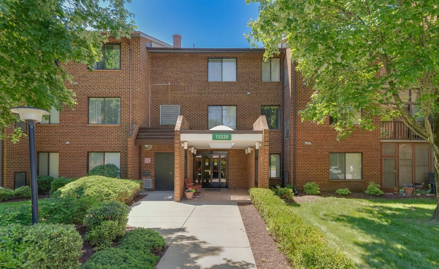 A large brick apartment building with a walkway leading to the entrance.