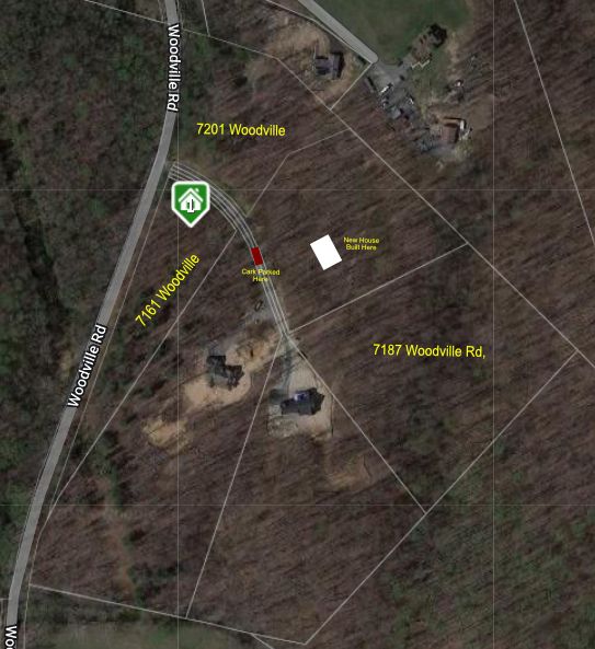 An aerial view of a house in the middle of a forest