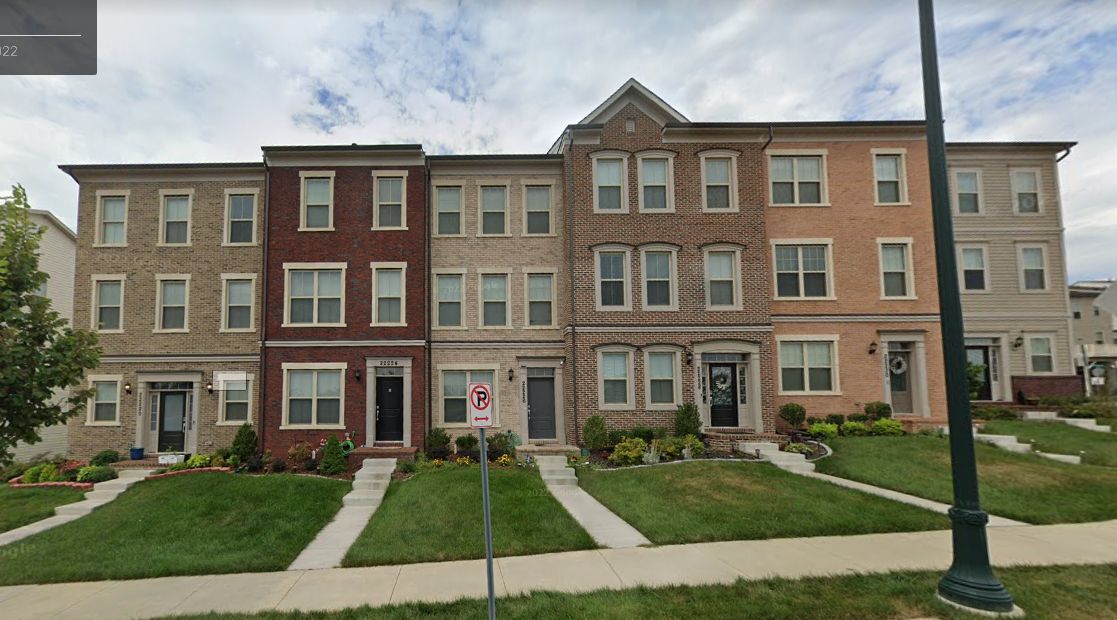 A row of houses with a lot of windows and a no parking sign in front of them.