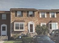 A brick house with a car parked in front of it