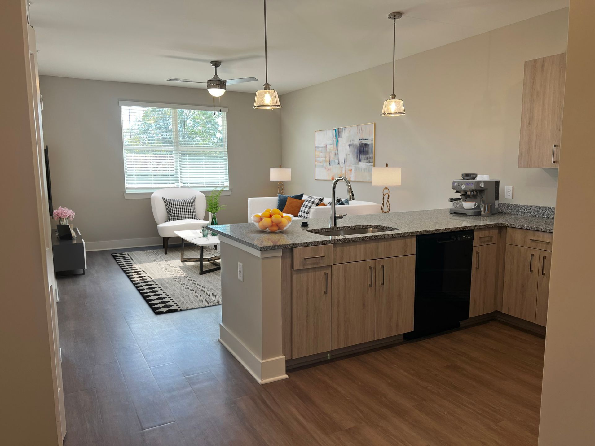 Open-concept kitchen with granite countertops and a connected living area.