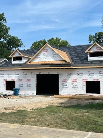 A house is being built with a roof and a garage.