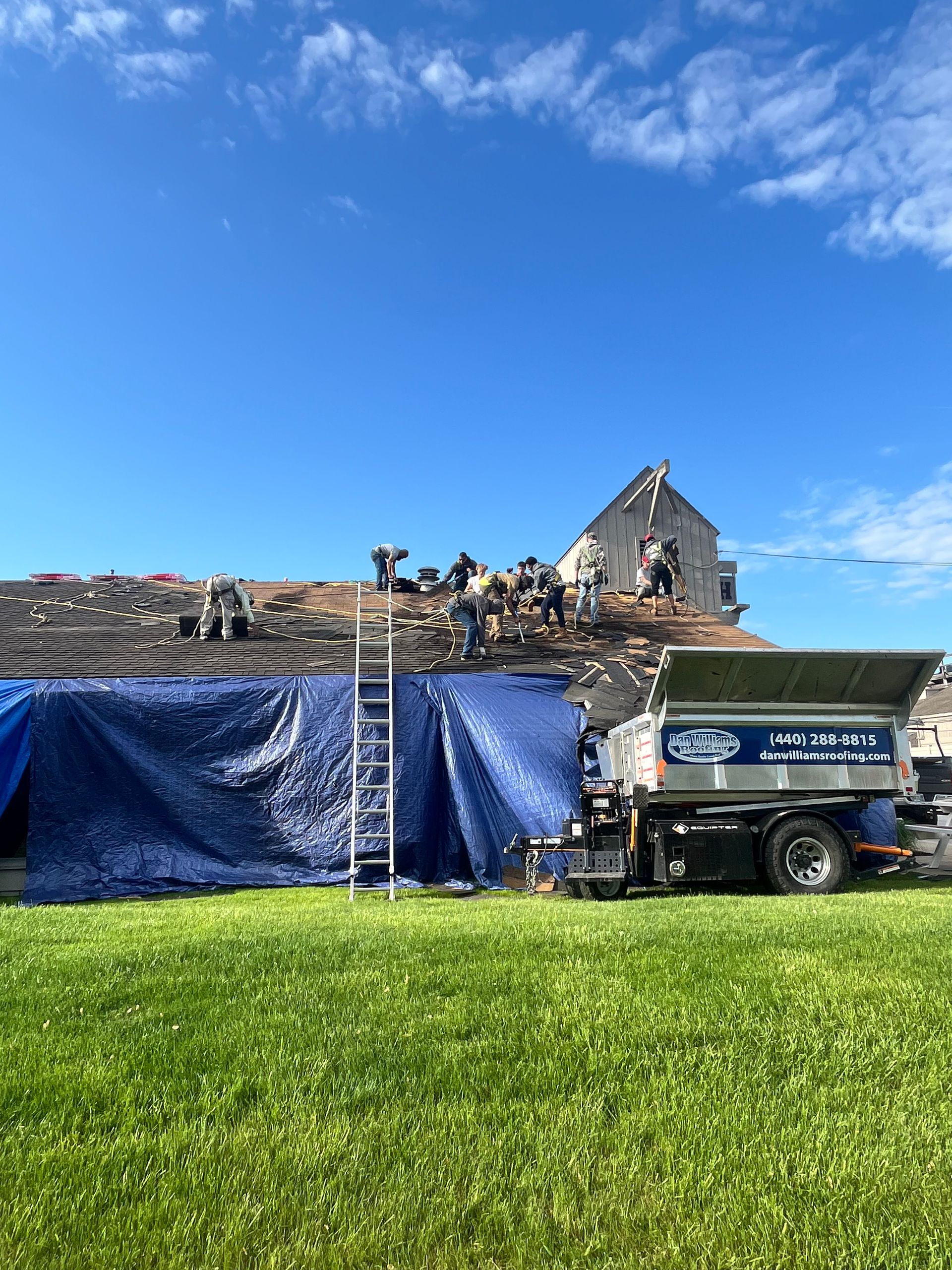 A truck is parked in a grassy field in front of a building.