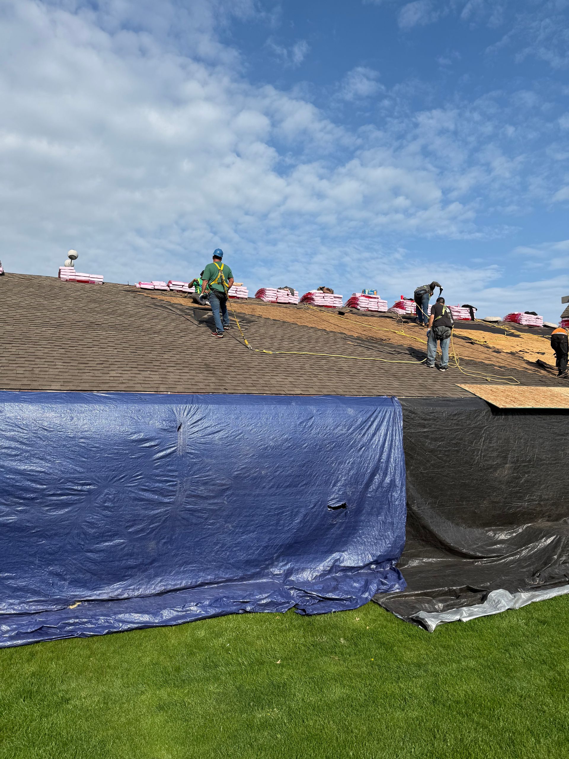 A group of people are working on a roof of a building.