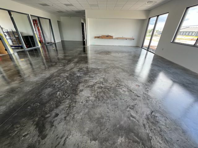 Empty commercial office with polished gray concrete floor and large windows