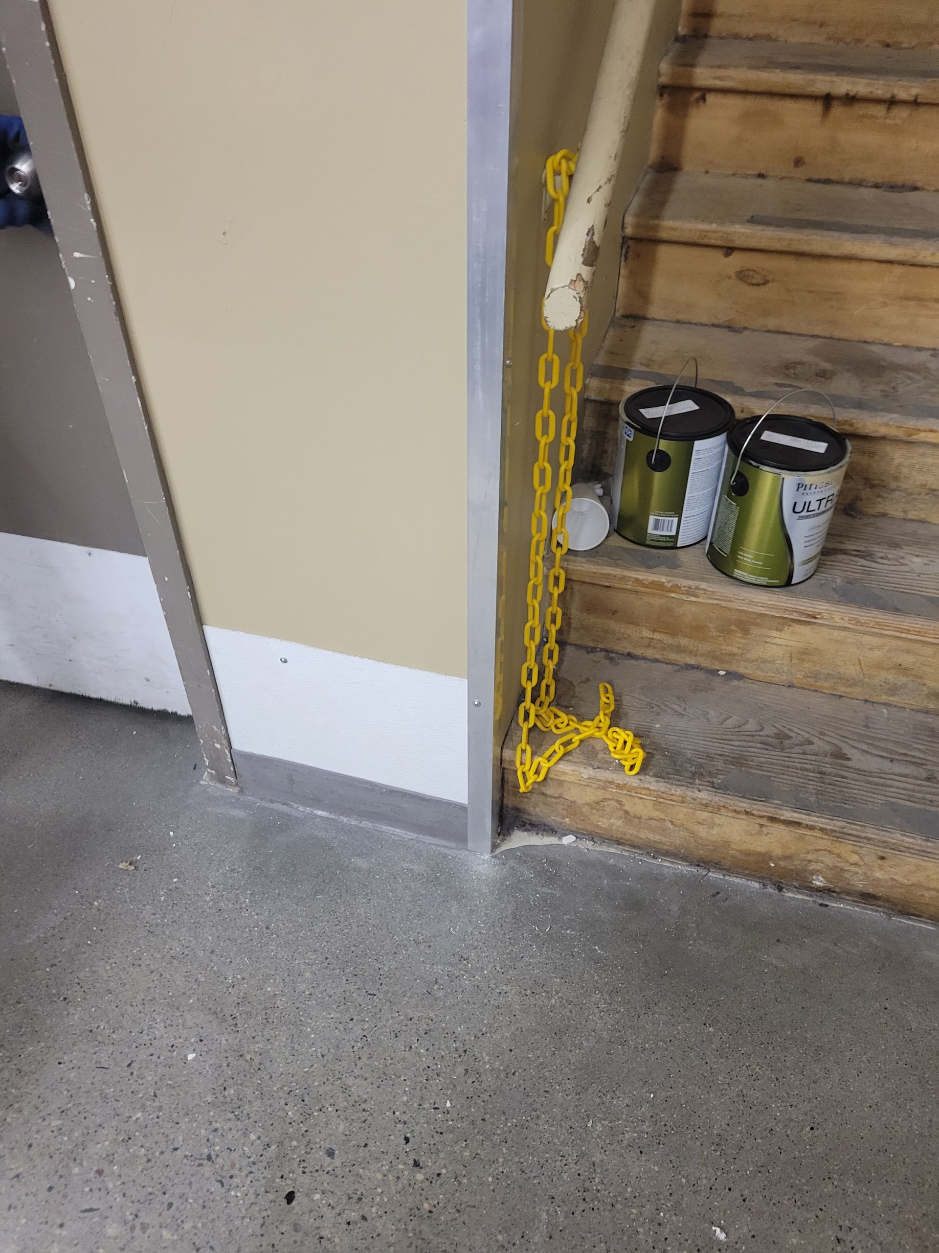 A yellow chain is attached to the side of a staircase