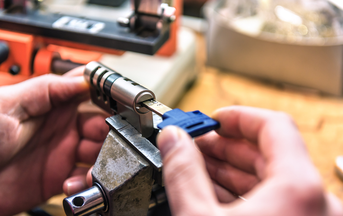 A person is cutting a key with a machine.