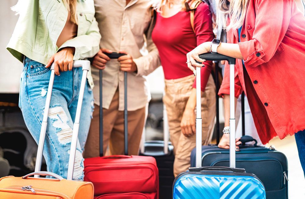 Four people with suitcases, ready for travel.