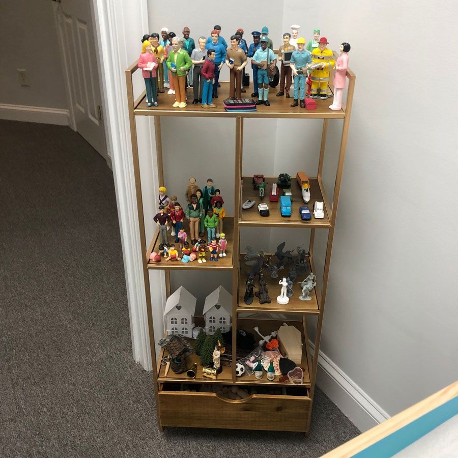 A wooden shelf filled with lots of toy figures