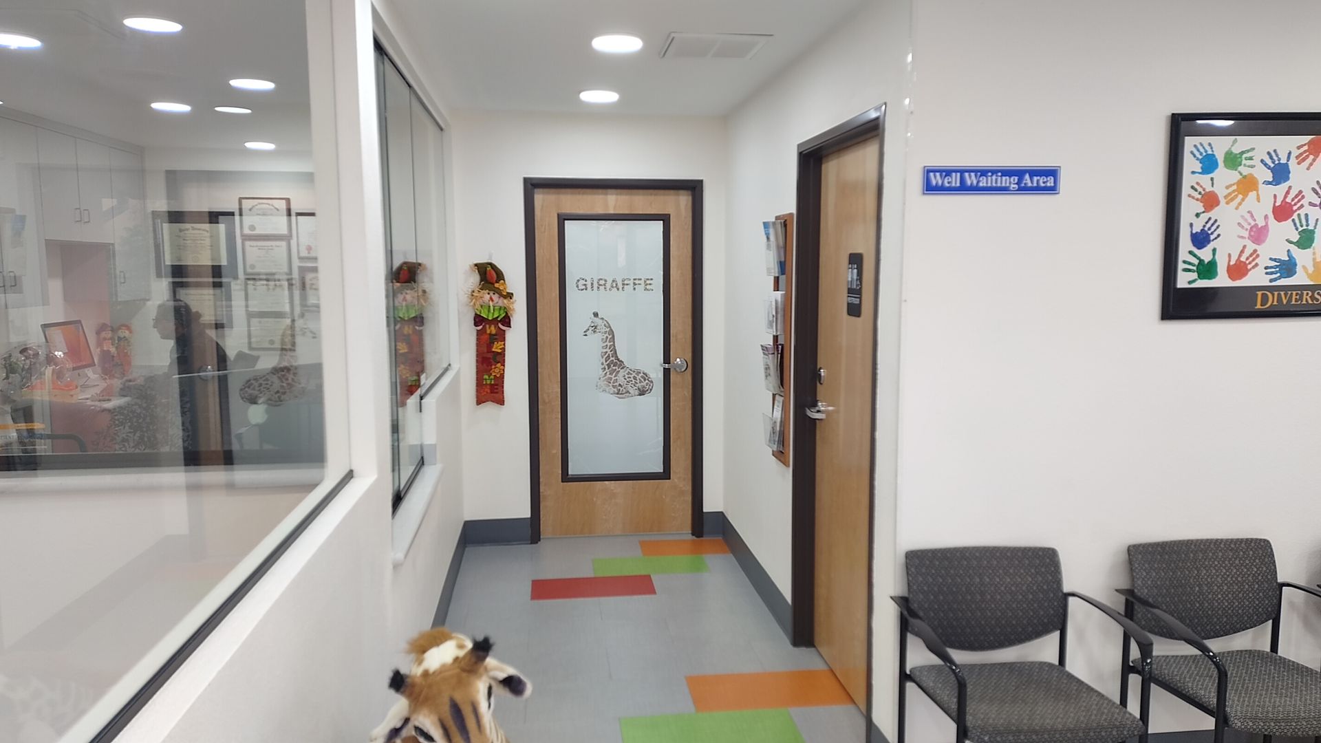 A hallway with chairs and a sign that says waiting room