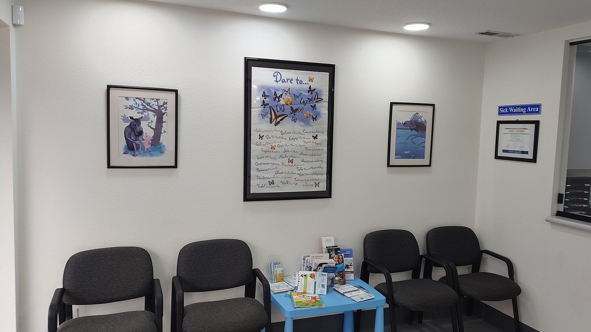 A waiting room with chairs and a blue table