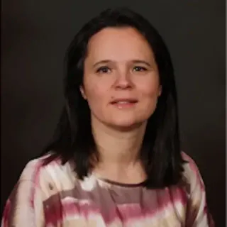 A woman with long dark hair is wearing a pink and white striped shirt.