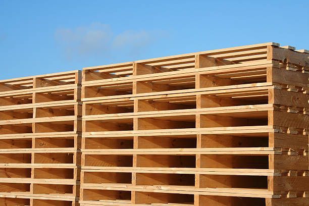 a stack of wooden pallets against a blue sky