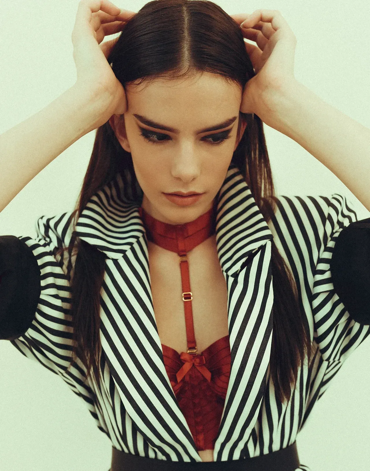 modelpose mit geradem scheitel und streifenoutfit mit schwarzem smokey eye in katzenform