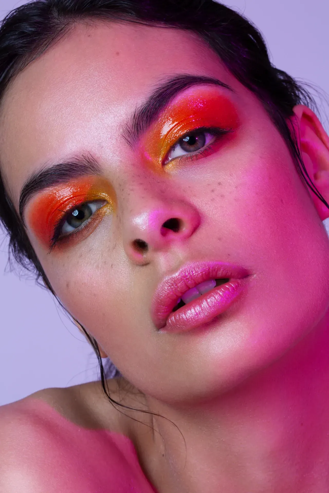 glossy augenmakeup in gelb orange und rot portrait mit pinkem licht