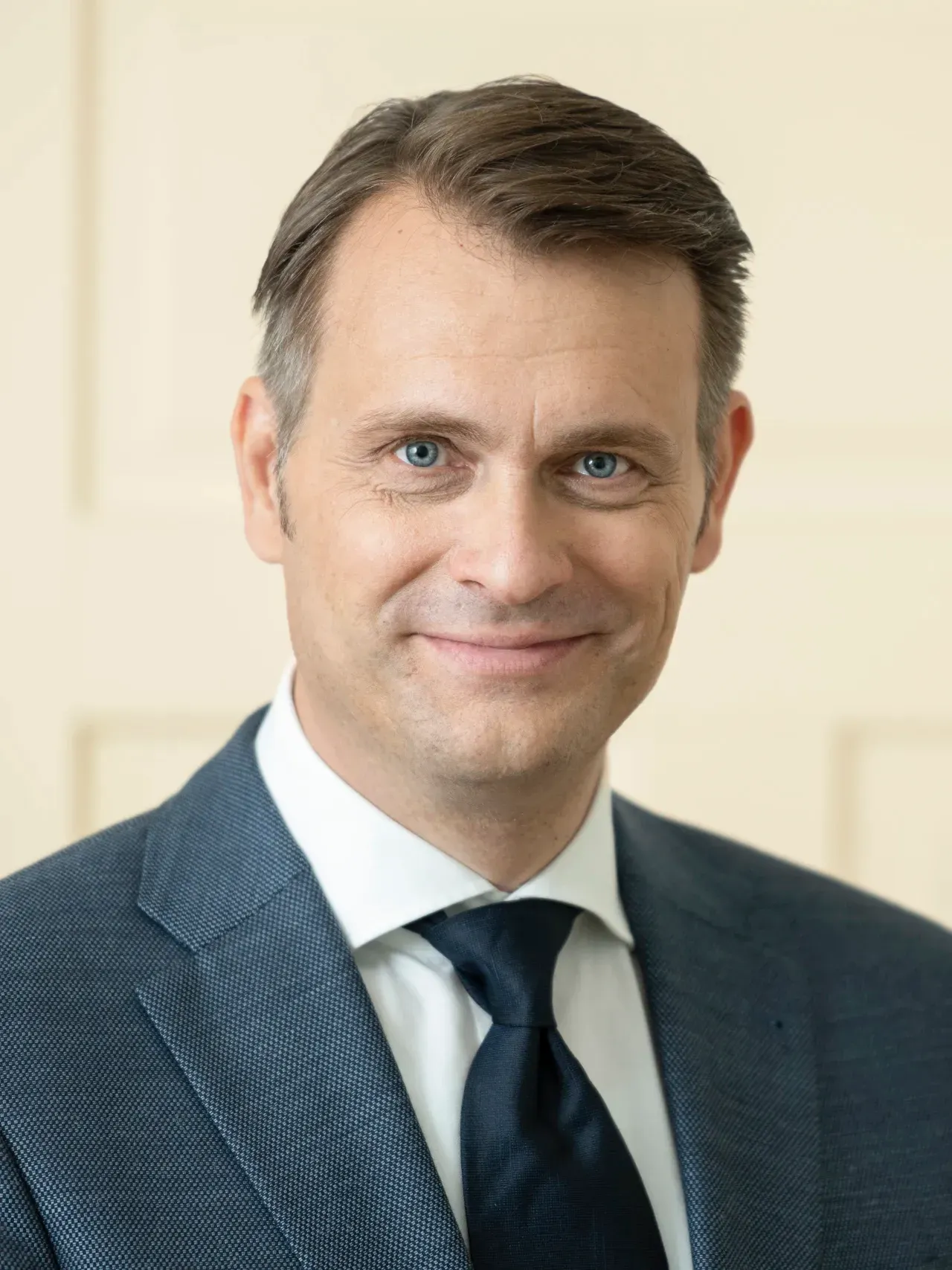 Portrait Firmeninhaber laechelt freundlich, helle Augen und dezentes Make-Up