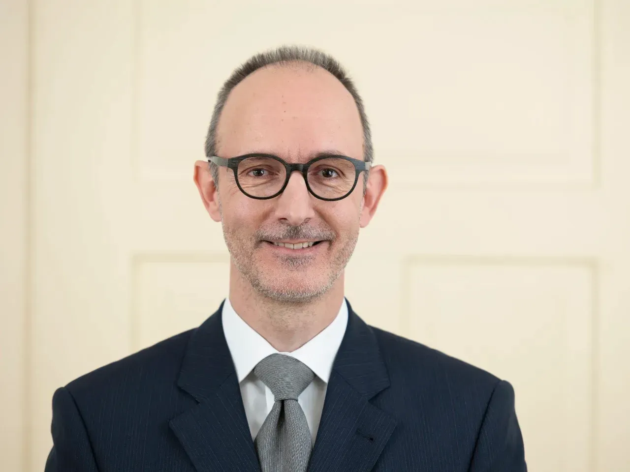 Firmeninhaberportrait, laechelnder Mann mit Brille, mattiert und gestylt