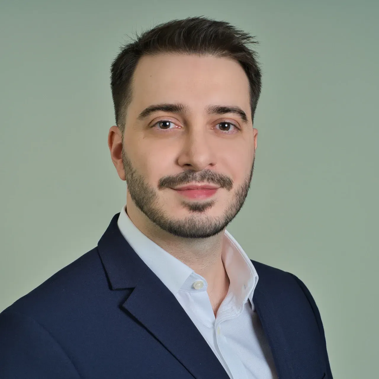 Mitarbeiterportrait junger Herr im Anzug sympathisch laechelnd und gepudert im Gesicht