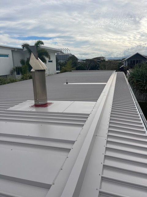 White Metal Roof With a Chimney and Gutter — Lee Pakau Roofing & Guttering in Banora Point, NSW