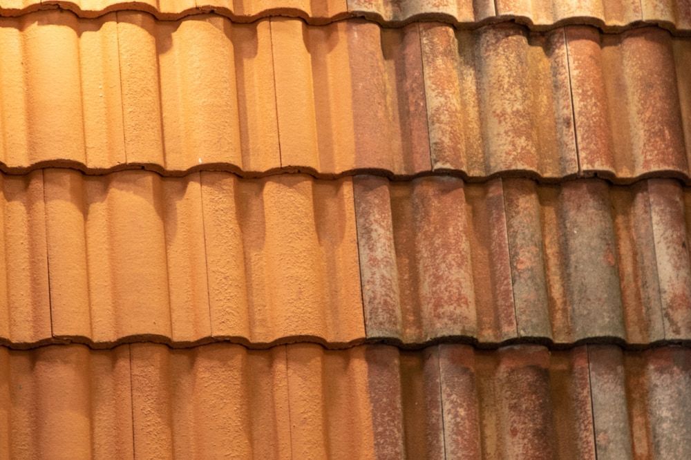 Comparison of a clean and dirty section of terracotta roof tiles. — Lee Pakau Roofing & Guttering in Murwillumbah, NSW