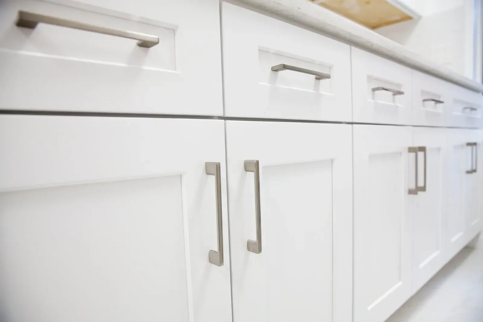 White kitchen cabinets with silver handles.