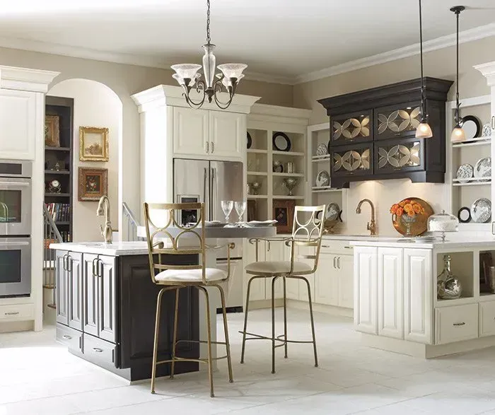 Elegant kitchen with white cabinets, dark island, and gold bar stools.