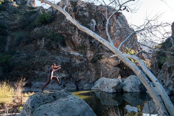 A person is jumping off a rock into a body of water.