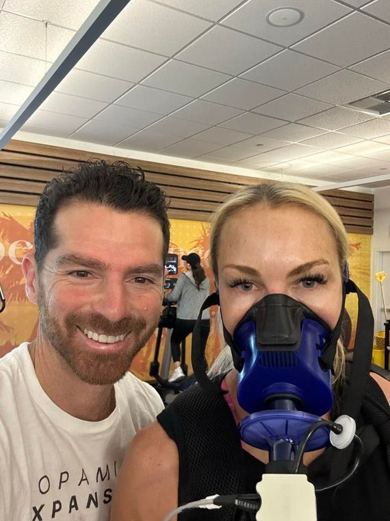 A man and a woman are wearing masks in a gym.