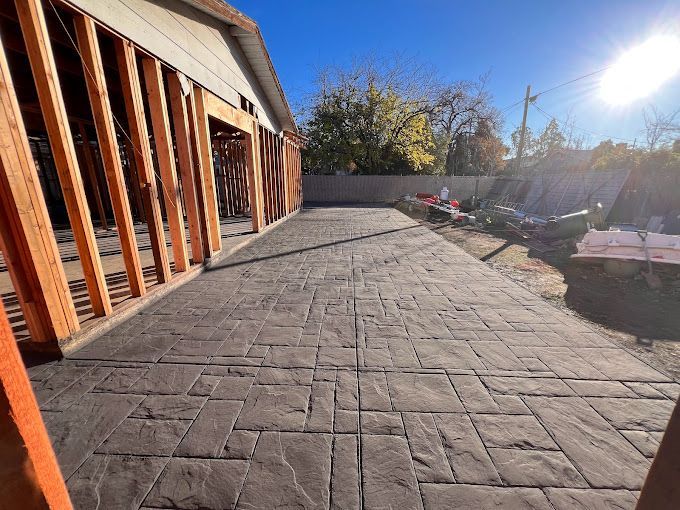 A concrete driveway in front of a house under construction.