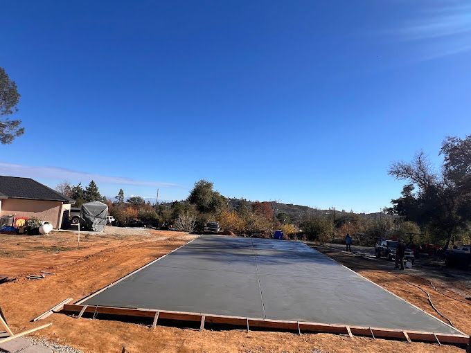 A large concrete slab is sitting in the middle of a dirt field.