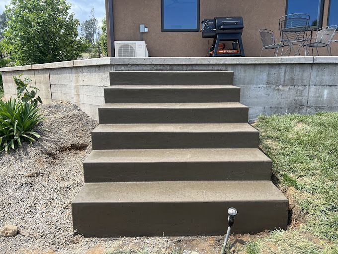 A set of concrete stairs leading up to a house.