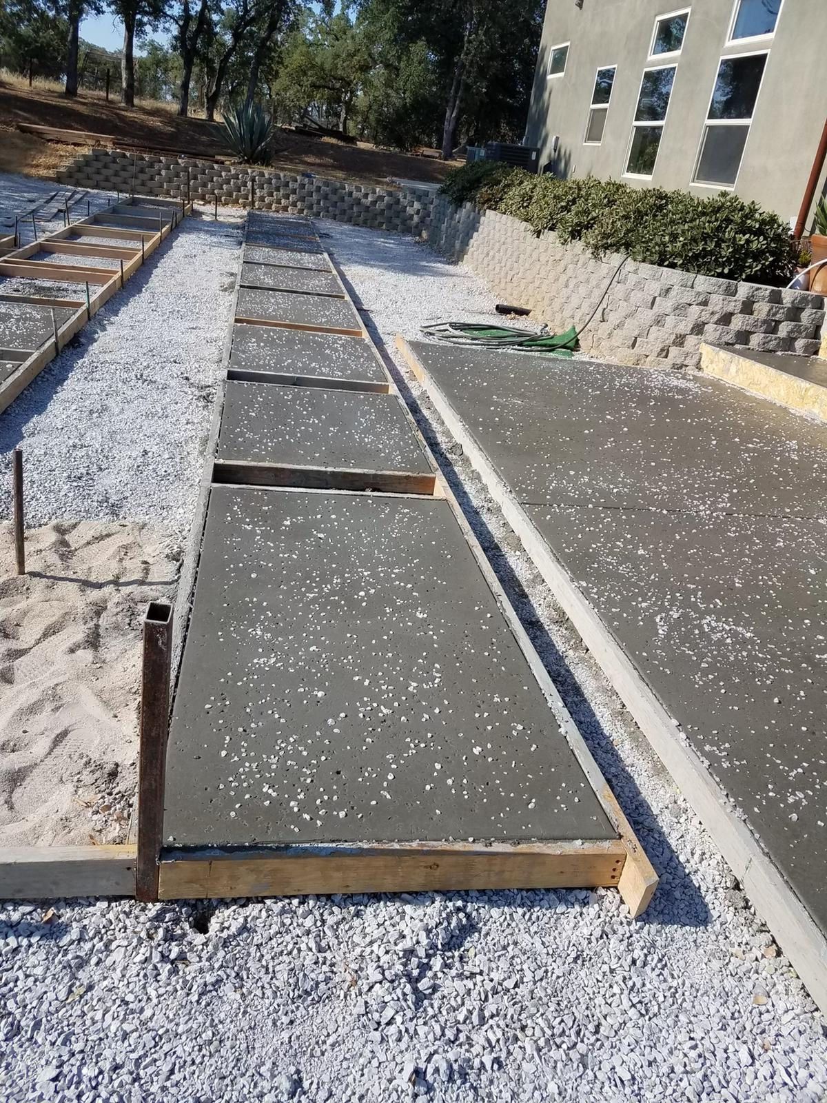 A concrete driveway is being built in front of a house.