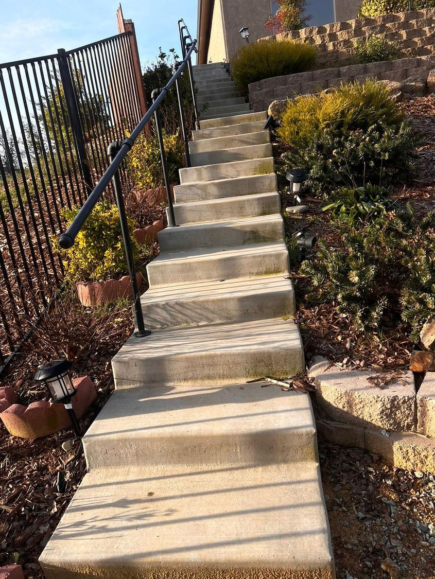 A set of concrete stairs leading up to a house.