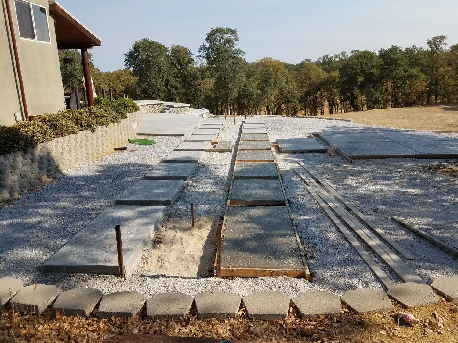 A concrete walkway is being built in front of a house.