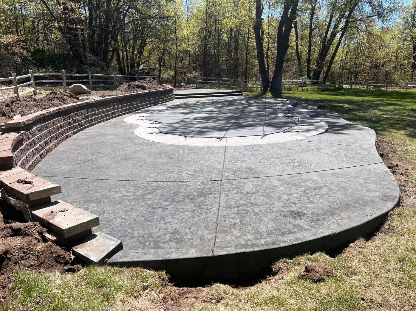 A concrete patio is being built in the middle of a park.