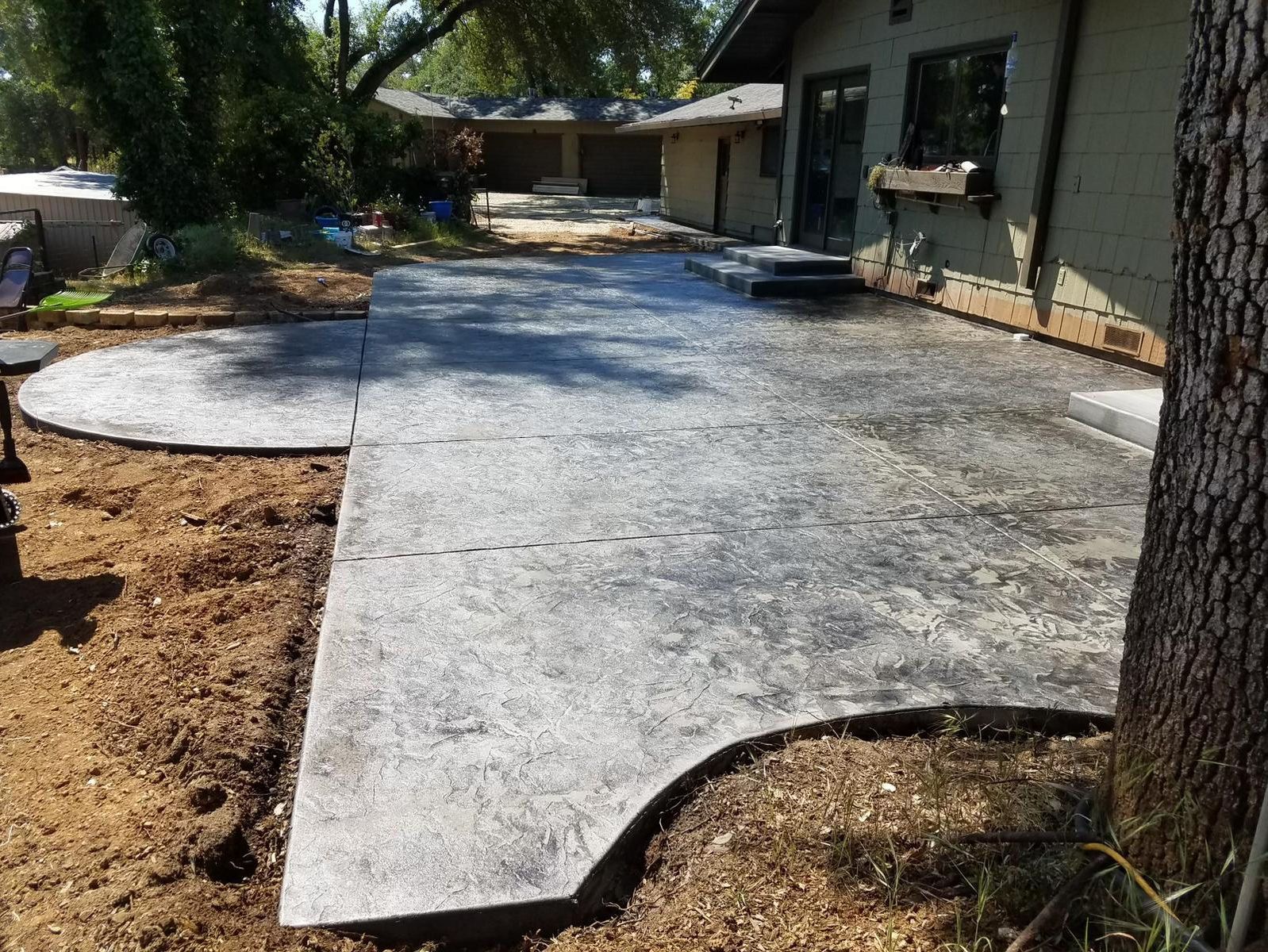 A concrete patio is being built in front of a house.