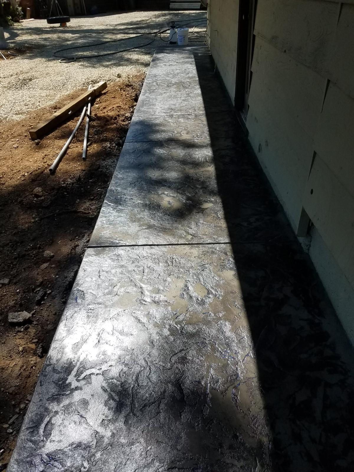 A concrete walkway is being built in front of a building.