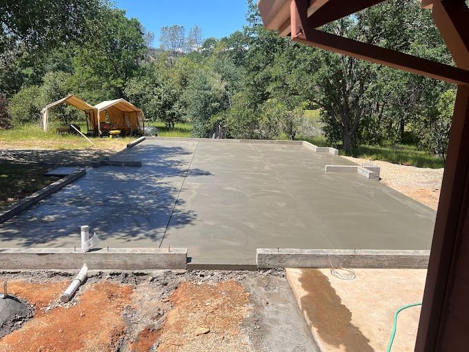 A concrete driveway with a tent in the background