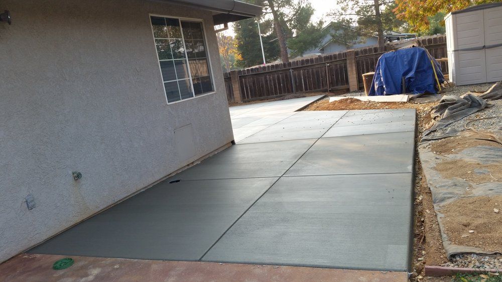 A concrete driveway is being built in front of a house.