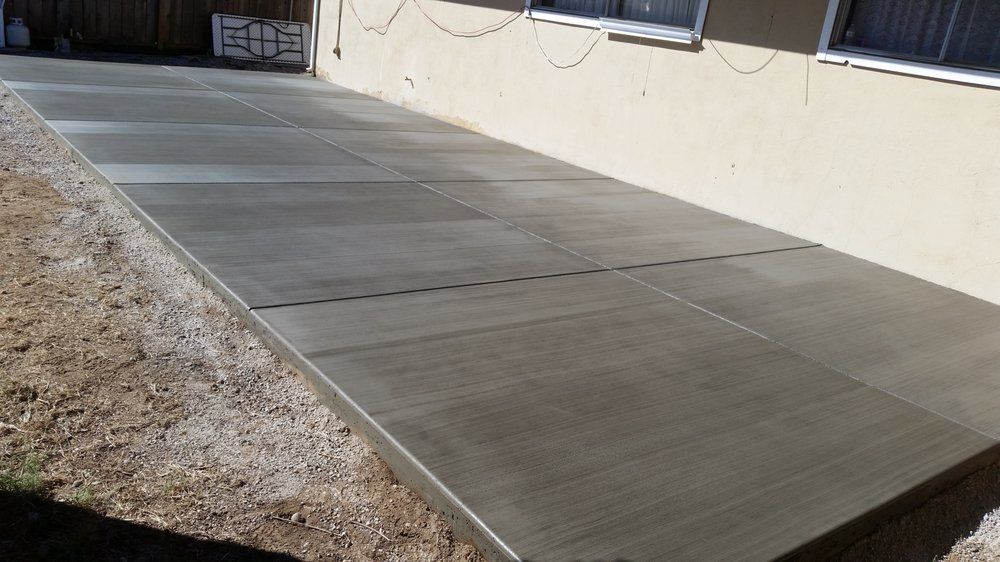 A concrete walkway is being built in front of a house.