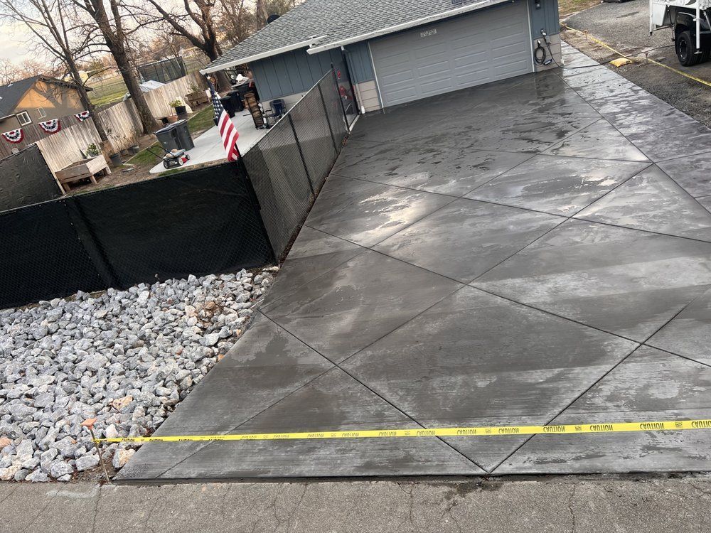 A concrete driveway is being built in front of a house.
