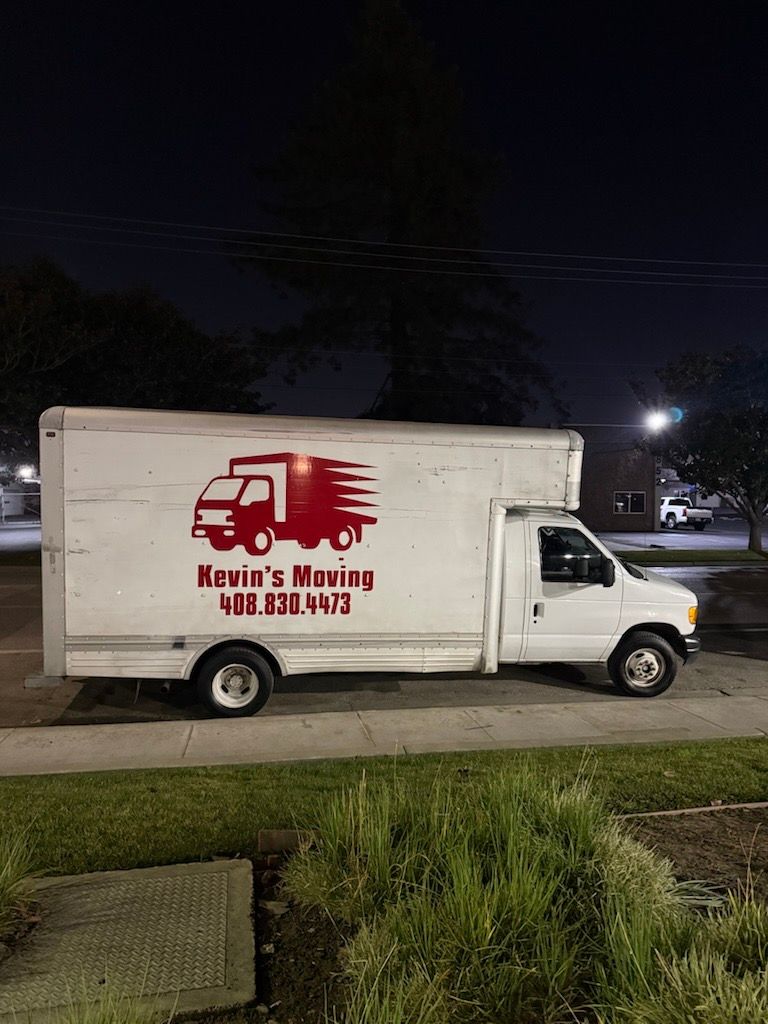 Truck loaded with cardboard boxes parked near an office building, ready for delivery or move.