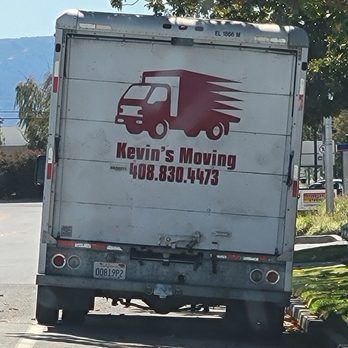 A wrapped sofa strapped to a truck's lift gate, ready for moving.