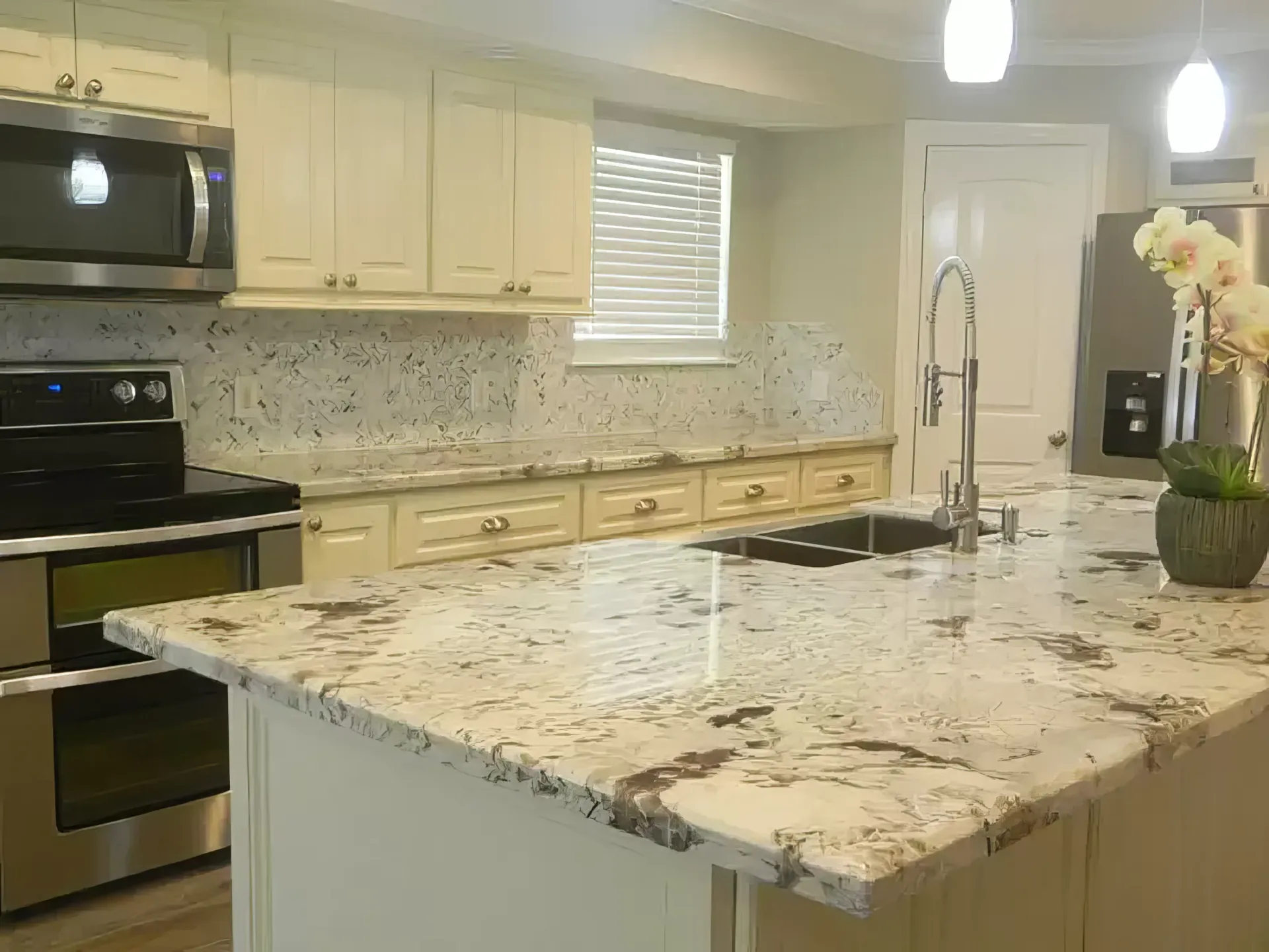 A kitchen with granite counter tops and stainless steel appliances.