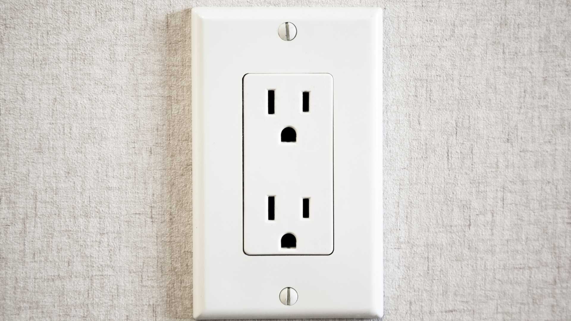 A close up of a white electrical outlet on a wall.