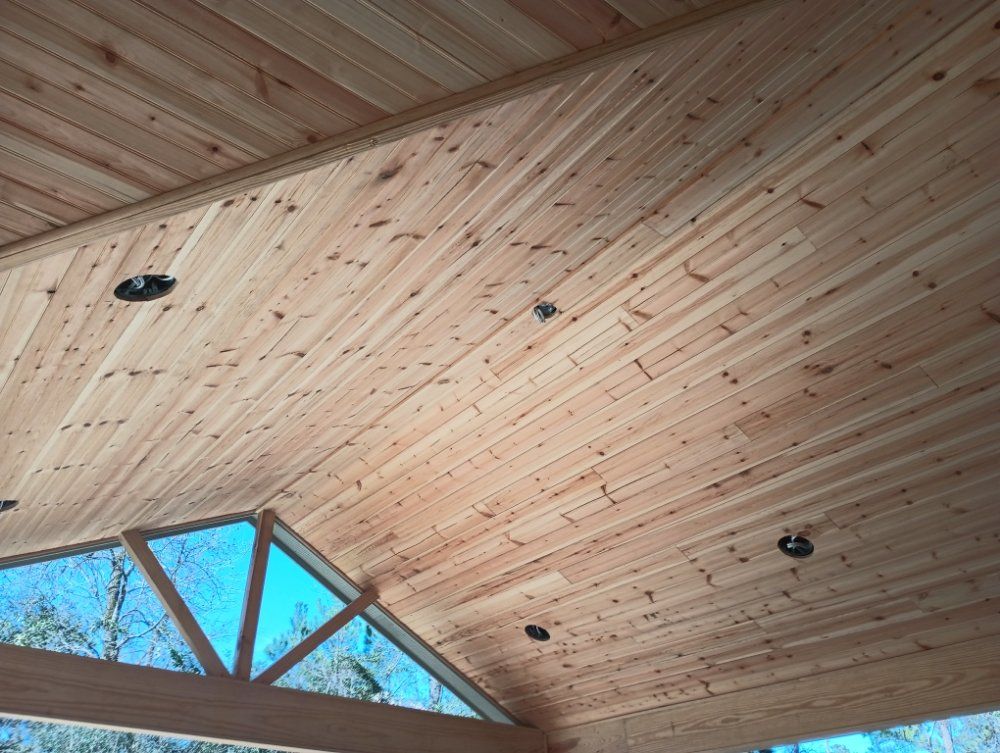 A wooden ceiling with a window in the middle of it