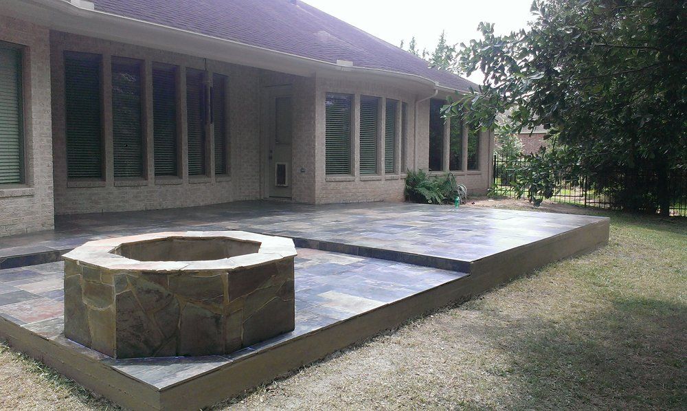 A fire pit is sitting on a patio in front of a house.