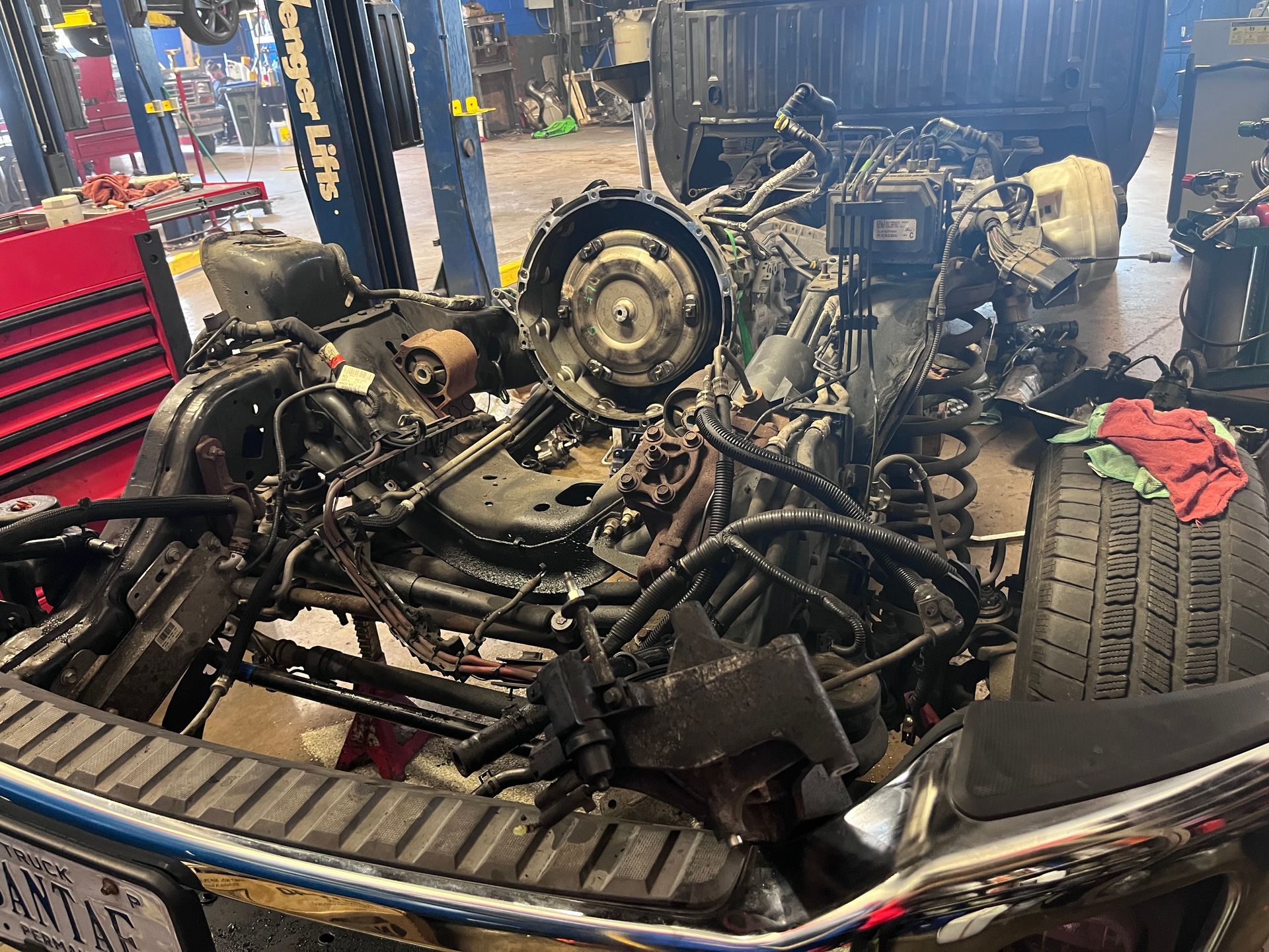 The engine of a truck is being dismantled in a garage.